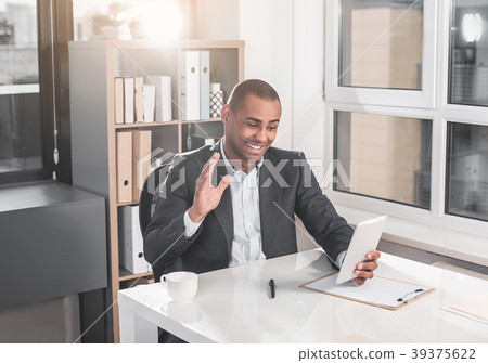 Glad businessman talking with help of gadget Glad businessman talking with help of gadget 39375622