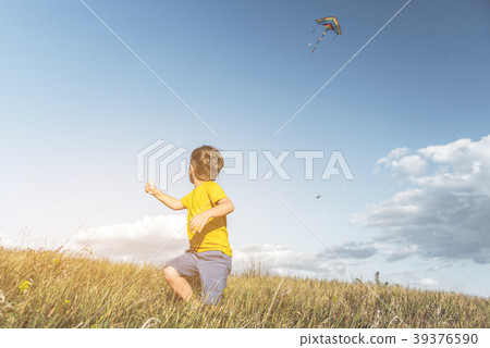 Joyful kid flying kite at countryside 39376590