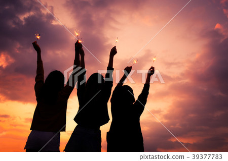 Asian group of friends lighting sparklers Asian group of friends lighting sparklers 39377783