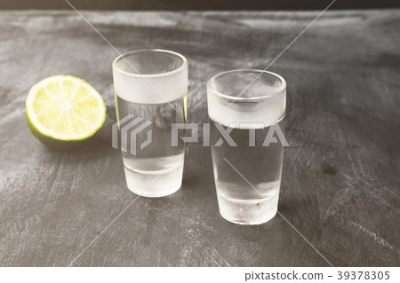 Cold vodka in shot glasses on a black background Cold vodka in shot glasses on a black background 39378305