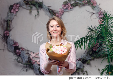 Photo of smiling female florist with bouquet in Photo of smiling female florist with bouquet in 39379419
