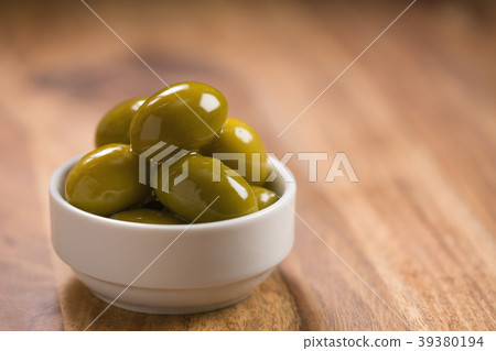 big green salted olives in white bowl on wooden big green salted olives in white bowl on wooden 39380194