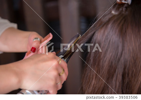 Hairdresser using a hair iron 39383506