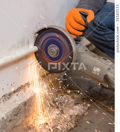 Worker cuts a metal pipe at a construction site Worker cuts a metal pipe at a construction site 39383531
