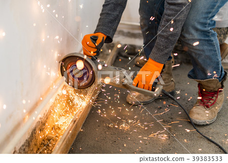 Worker cuts a metal pipe at a construction site Worker cuts a metal pipe at a construction site 39383533