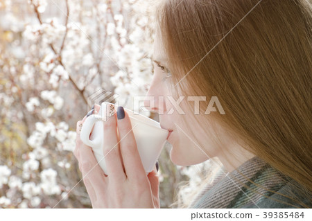Young woman drink a tea. Enjoying the spring 39385484
