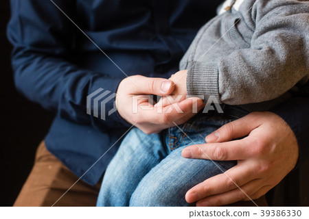 Hands of baby boy and adult man close-up 39386330