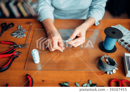 Female hands with pliers, top view, needlework Female hands with pliers, top view, needlework 39387455