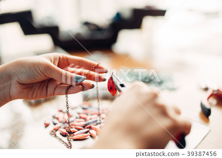 Female person holds pliers, bijouterie making Female person holds pliers, bijouterie making 39387456