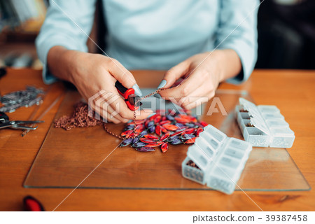 Female hands with pliers, bijouterie making Female hands with pliers, bijouterie making 39387458