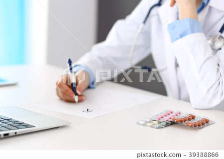 Closeup of pills opposit female doctor filling up 39388866