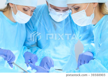 Group of surgeons at work while operating at 39388903