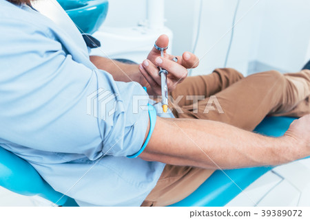Patient using a dental anesthetic syringe for Patient using a dental anesthetic syringe for 39389072