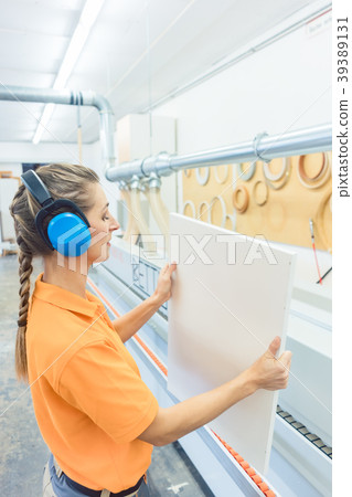 Woman carpenter working in furniture factory Woman carpenter working in furniture factory 39389131
