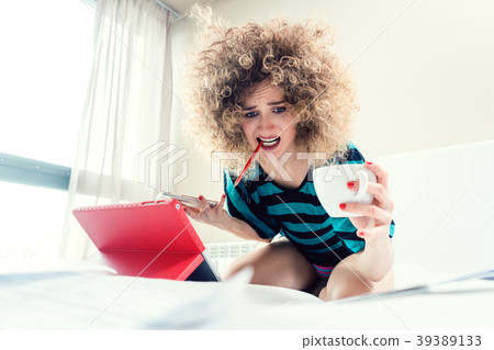 Woman student on her bed learning for exam in 39389133