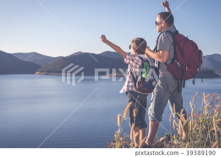 Happy family standing near the lake at the day time. 39389190