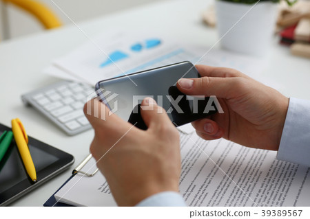 A businessman holds a new smartphone in A businessman holds a new smartphone in 39389567