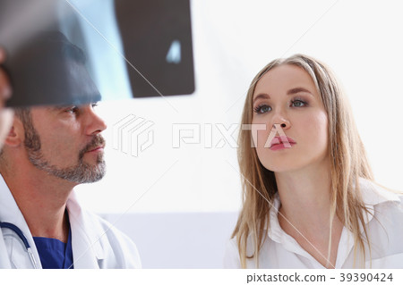 Mature male doctor hold in arm and look at xray Mature male doctor hold in arm and look at xray 39390424
