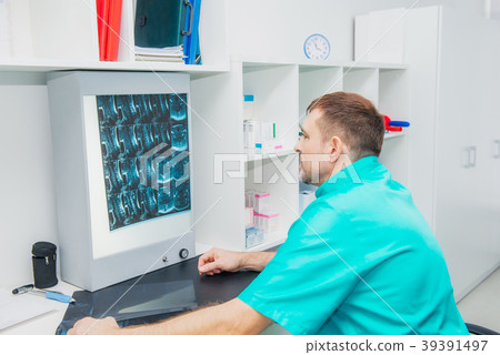 Male doctor looking at x-ray image cervical spine 39391497