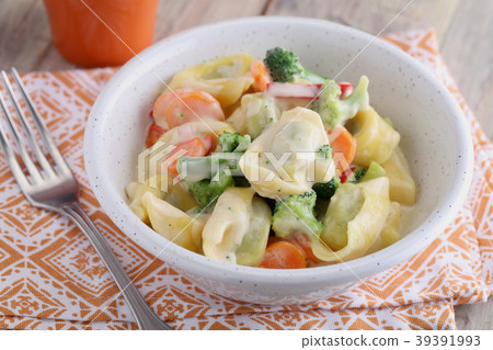 Tortellini with vegetables under cream sauce 39391993