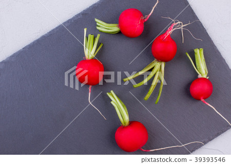Five radishes on slate, top view. 39393546
