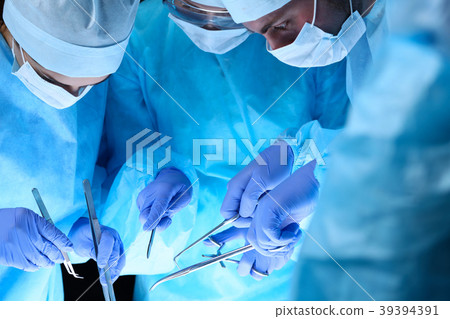 Group of surgeons at work while operating at Group of surgeons at work while operating at 39394391