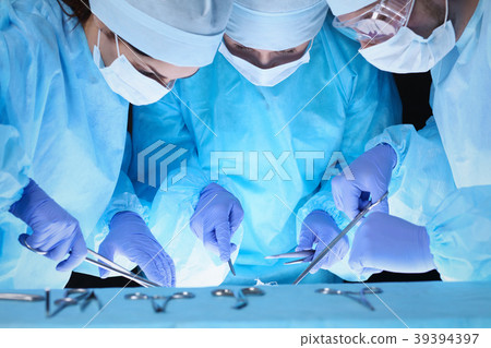 Group of surgeons at work while operating at 39394397