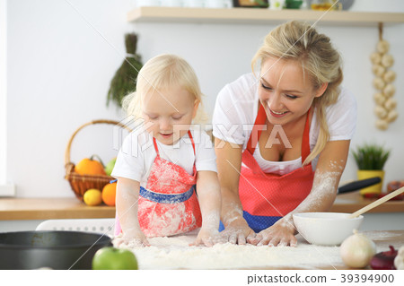Little girl and her blonde mom in red aprons Little girl and her blonde mom in red aprons 39394900