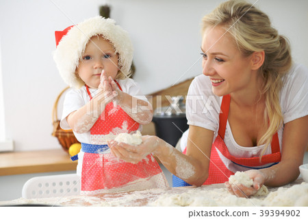 Little girl and her blonde mom in red aprons 39394902