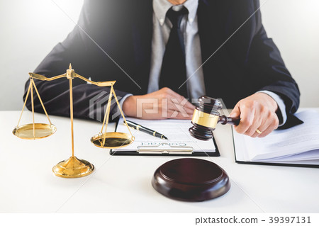 Male Judge lawyer In A Courtroom Striking The Gavel on sounding Male Judge lawyer In A Courtroom Striking The Gavel on sounding 39397131