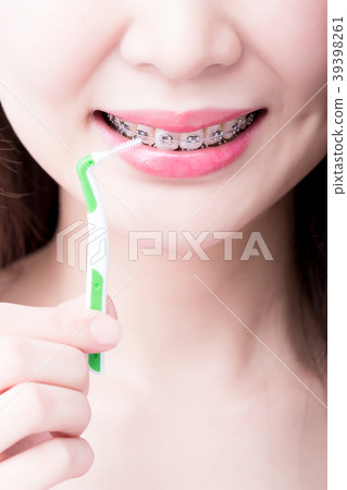 woman wear brace and take interdental brush 39398261