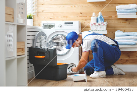 working man   plumber repairs  washing machine in   laundry. 39400453