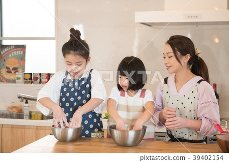 Two elementary school sisters helping in the kitchen Two elementary school sisters helping in the kitchen 39402154