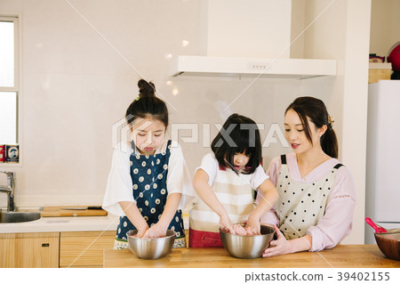 Two elementary school sisters helping in the kitchen Two elementary school sisters helping in the kitchen 39402155