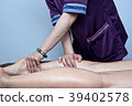 理療師正在按摩女性客戶的腿部 39402578