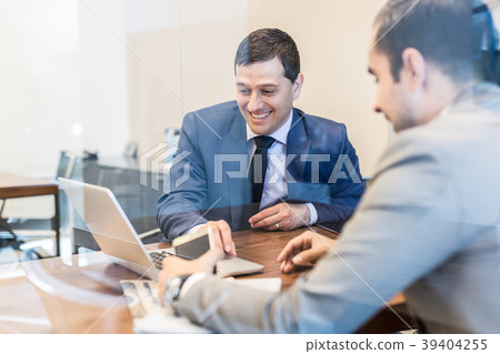 Two young businessmen using laptop computer at Two young businessmen using laptop computer at 39404255