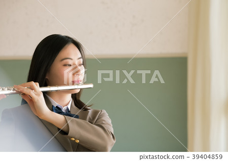 Female student blowing a flute Female student blowing a flute 39404859