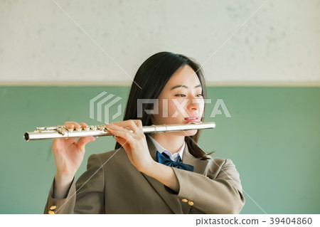 Female student blowing a flute Female student blowing a flute 39404860