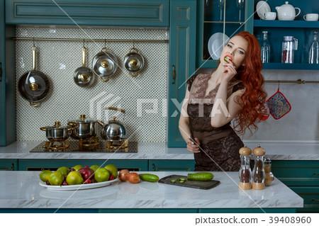 Red-haired woman in the kitchen. 39408960