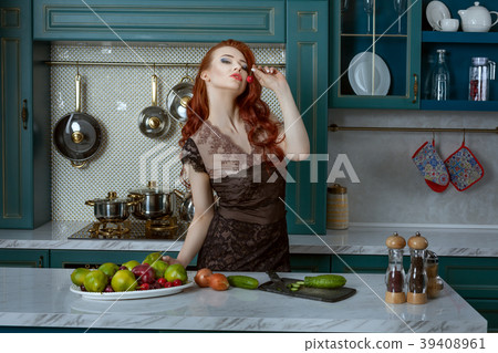 Beautiful red-haired woman in the kitchen. 39408961