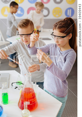 Diligent classmates adding chemicals to sample Diligent classmates adding chemicals to sample 39409443