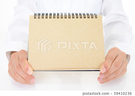 Female hand holding a notebook Female hand holding a notebook 39410236