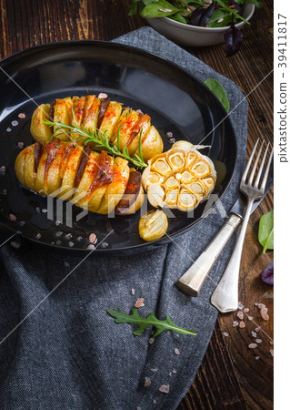 Baked hasselback potatoes. 39411817