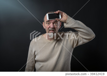old man does not understand his smartphone 39412419