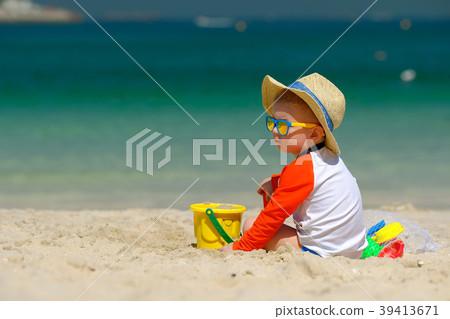 Two year old toddler playing on beach Two year old toddler playing on beach 39413671