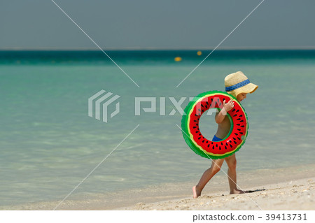 Toddler boy with swim ring on beach 39413731