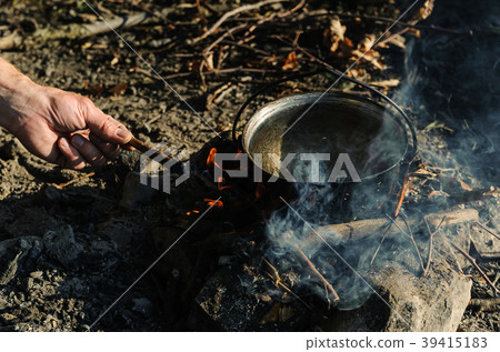 Kettle on charcoal fire. 39415183