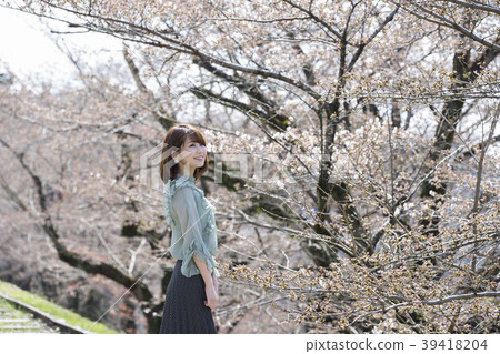 Young woman looking at cherry blossoms at kicking up line in Higashiyama Ward, Kyoto City, Kyoto Prefecture 39418204