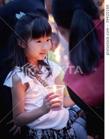 Girl staring at something with a candle in one hand Girl staring at something with a candle in one hand 39420166