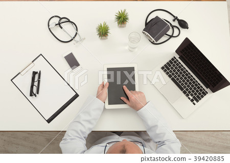 Doctor sitting at office with tablet, top view 39420885